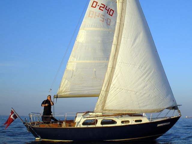 240, HAVNEHEKSEN, Kalkbrænderihavnen (Sundkrogen) København, DK. Ejerforhold: Et bådfællesskab her repræsenteret ved Jesper Hasseltoft. Motor: Stadig den oprindelige Bukh DV10. Nyeste forbedring: Udstyret med spilerudrustning og lettere brugt spiler fra en Albin Vega. Her er Havneheksen fotograferet i meget let luft en sommeraften ud for Svanemøllen i København.