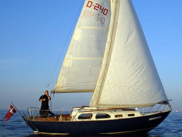 240, HAVNEHEKSEN, Kalkbrænderihavnen (Sundkrogen) København, DK. Ejerforhold: Et bådfællesskab her repræsenteret ved Jesper Hasseltoft. Motor: Stadig den oprindelige Bukh DV10. Nyeste forbedring: Udstyret med spilerudrustning og lettere brugt spiler fra en Albin Vega. Her er Havneheksen fotograferet i meget let luft en sommeraften ud for Svanemøllen i København.